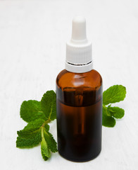 Bottle of mint oil and fresh mint