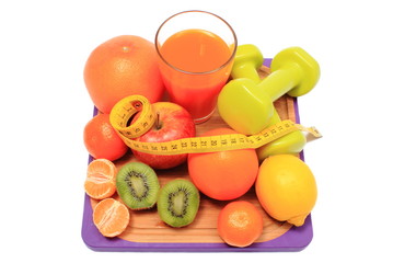 Fresh fruits, dumbbells, tape measure and glass of juice