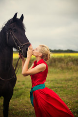 Obraz premium Young cute woman in saturate long dress with black strong and mu