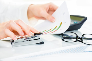 Close-up of female hand stapling the documents