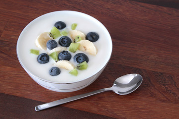 Yogurt with blueberries, kiwi and banana slices.