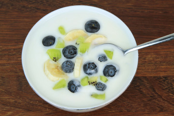 Yogurt with blueberries, kiwi and banana slices.