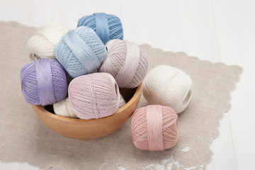 Fototapeta na wymiar Thread Bobbins in a Wooden Bowl. Natural Linen Napkin with Croch