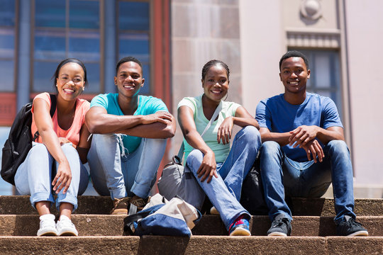 group of african student sitting outside college building