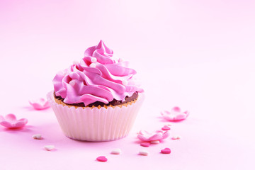 Delicious cupcake on pink background