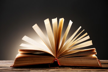 Open book with light over dark background