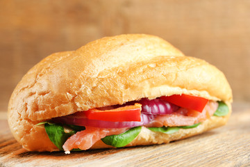 Sandwich with salmon on wooden background