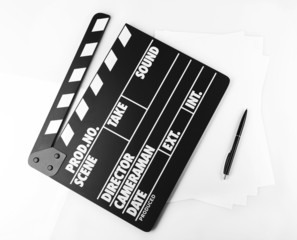 Movie clapper with sheets of paper and pen on white background