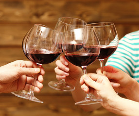 Clinking glasses of red wine in hands
