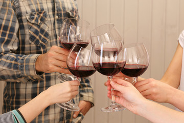 Clinking glasses of red wine in hands