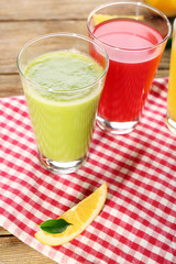 Fresh juices with fruits on wooden table