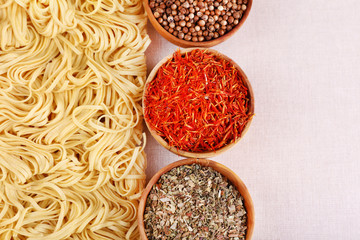 Different dry instant noodles with spices on flax background