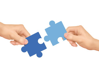 cooperation concept: hands holding jigsaw pieces