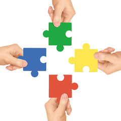cooperation concept: hands holding jigsaw pieces