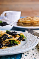 A stack of pancakes with black caviar