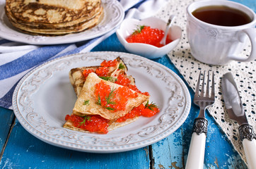 A stack of pancakes with red caviar