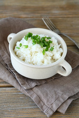 Obraz na płótnie Canvas Tasty rice with green onions in a bowl