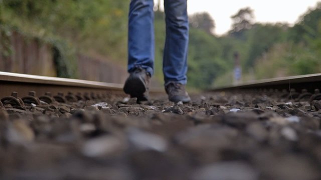 ragazzo che cammina tra i binari rotaie