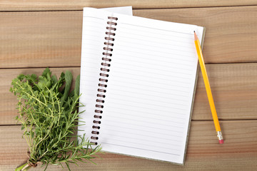 Blank notebook and pencil with a bunch of herbs