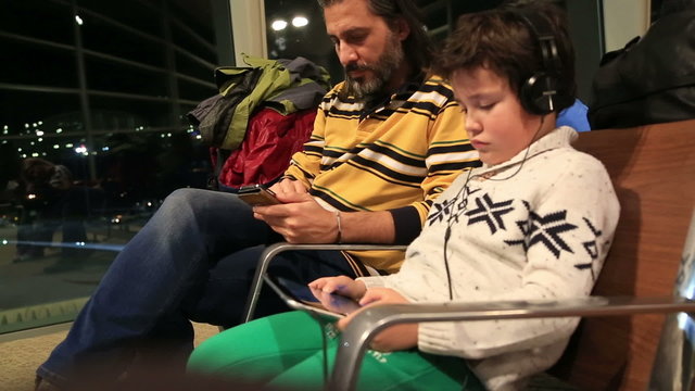 Father and son waiting at the airport