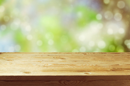 Old wooden deck table with spring bokeh background