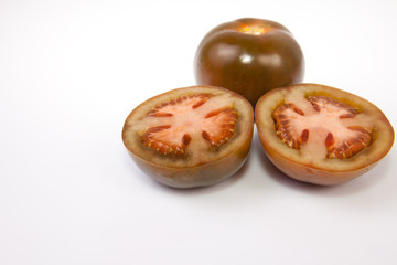 Fototapeta premium Whole and sliced kumato tomatoes