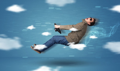 Obraz premium Funny racedriver young man driving between clouds concept