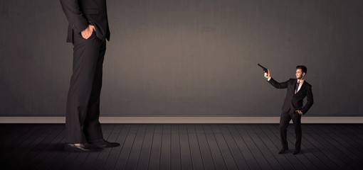 Obraz premium Little bussinesman in front of a giant boss legs concept