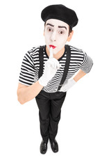 Mime artist holding a finger on his lips