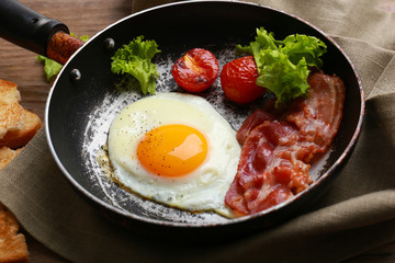 Bacon and eggs on rustic wooden planks background