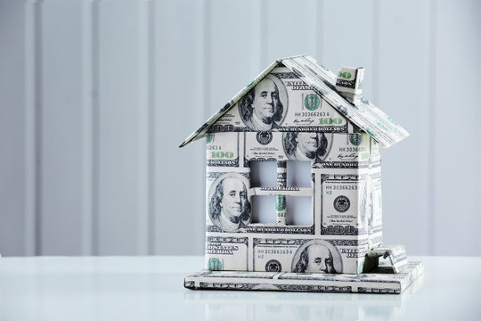 Money House On Table On Light Background