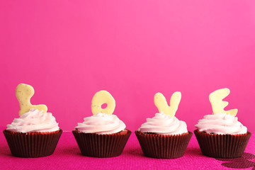 Delicious Valentine Day cupcakes on pink background