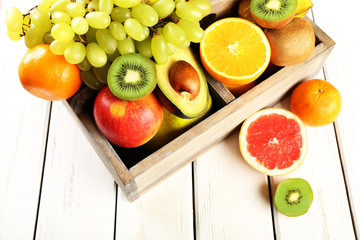 Assortment of fruits in box on wooden table