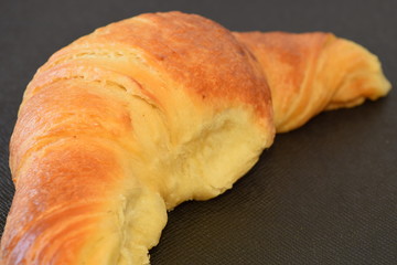 Fresh croissant on a black background.