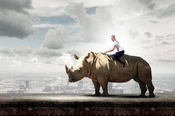 Woman saddling rhino © Sergey Nivens