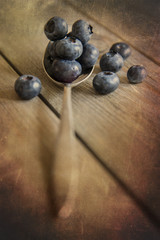 Blueberries in rustic kitchen setting with old wooden background