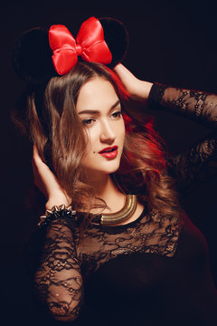 Portrait of a beautiful model with a red bow on a dark backgroun