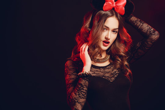 Portrait of a beautiful model with a red bow on a dark backgroun