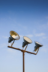 Three projectors of light against the sky background