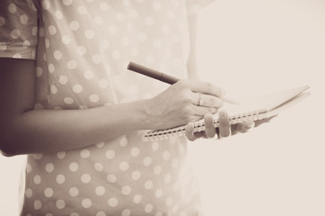 Young female is writing notes and planning her schedule