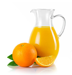 Jug with orange juice and fruits with green leaves isolated
