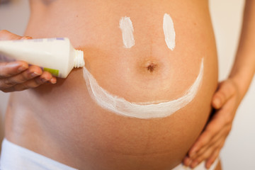 Pregnant woman with a smiley on her stomach