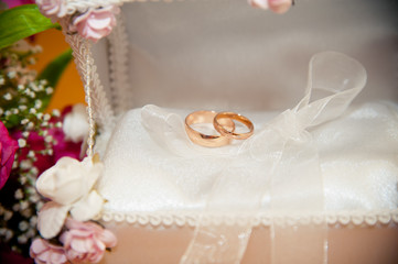Wedding rings in the trunk next to the wedding bouquet bride