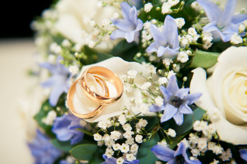 wedding rings lie on a bouquet