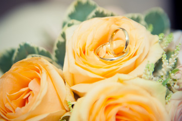 wedding rings lie on a bouquet