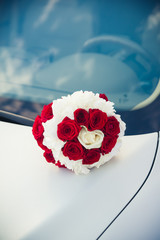 bridal bouquet  lying on the hood of a car
