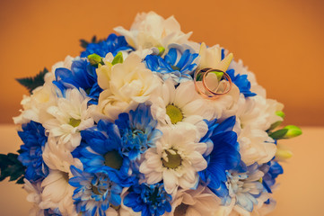 wedding rings lie on a bouquet