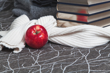 Stack of books with glossy edge and red apple