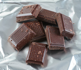 Broken dark chocolate pieces in silver foil
