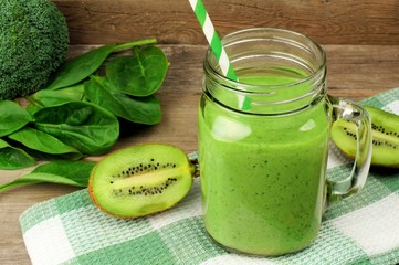 Healthy green smoothie with spinach and kiwi in a jar mug